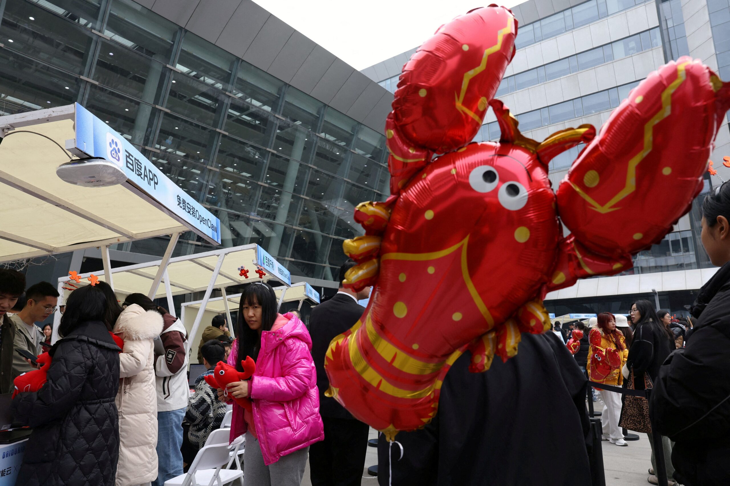 A massive crowd gathered in front of the OpenClaw promo booth, holding a giant inflatable lobster high—the most hilarious tech scene of 2026